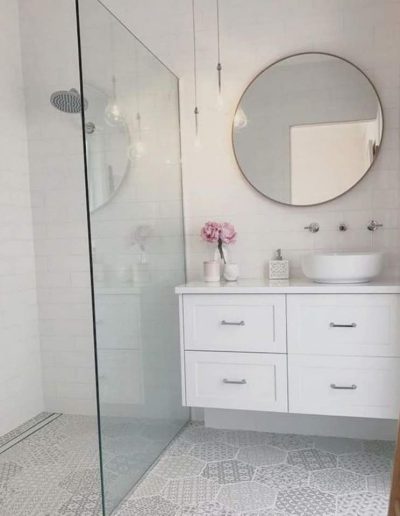 Baño blanco con espejo redondo