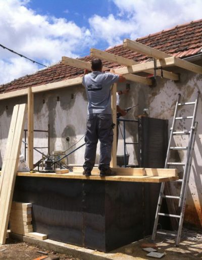 Trabajador en la construcción de porche exterior en madera