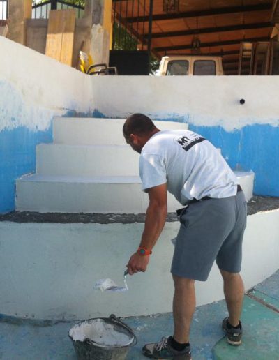 Detalle construcción escaleras de piscina obra con trabajador