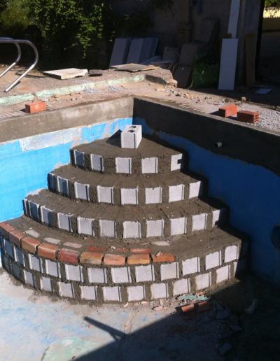 Detalle construcción escaleras de piscina obra sin trabajador
