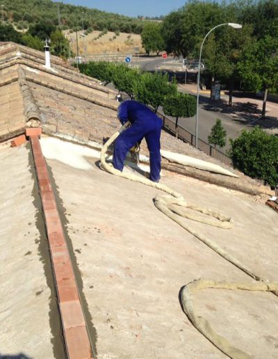 Detalle aislamiento proyectado de tejado con trabajador proyectando